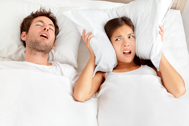 Man snoring in bed and keeping his wife awake